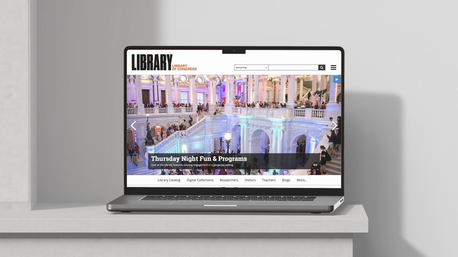 A laptop displaying the redesigned homepage of the Library of Congress website, featuring a colorful hero image of the Jefferson Building interior during an evening event, with the headline “Thursday Night Fun & Programs.”